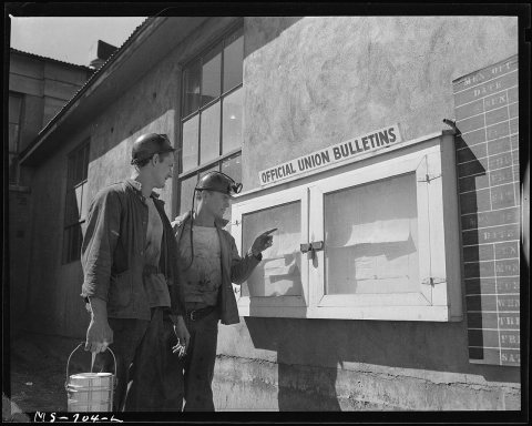 J. M. Hawkins (left) former pharmacists mate in the U.S. Navy and Wm. Smith, former Marine, read notice on the... - NAR…