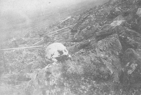 Human skull from ancient pit resting on ground, Kingegan, Alaska, between 1901 and 1906
