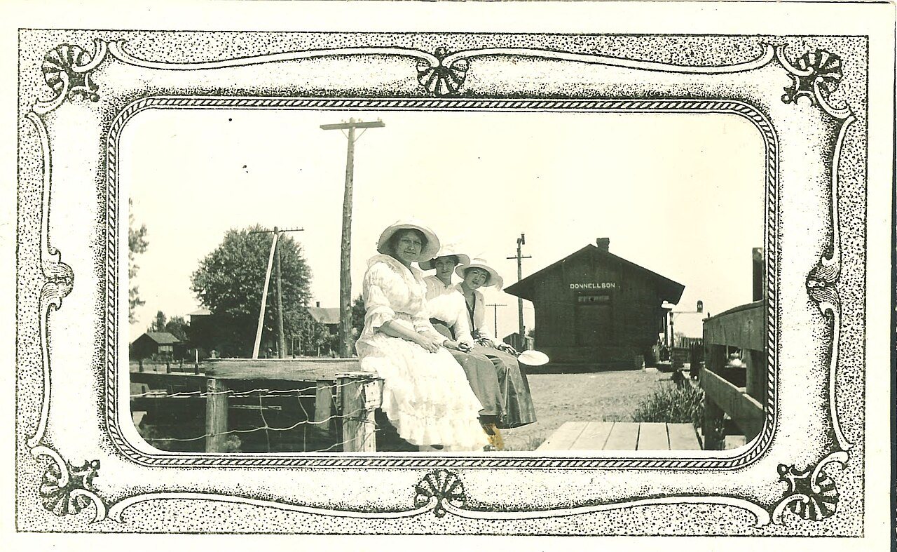 Women sitting at the train depot in Donnellson, Iowa, 1910s