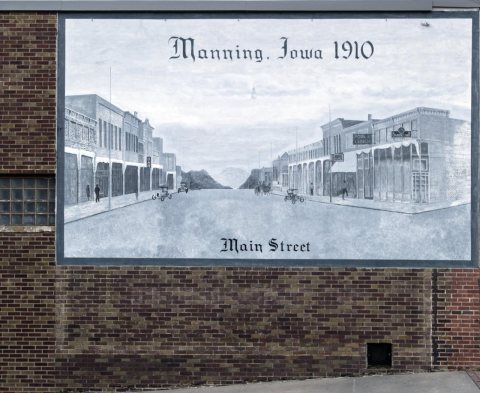 A 2016 view, via a downtown mural, of lightly traveled Main Street in downtown Manning, Iowa 106 years previously