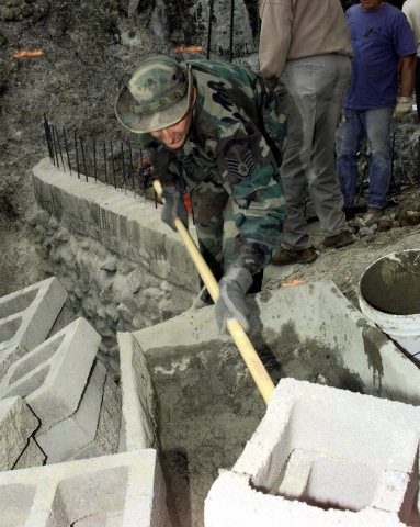 US Air Force STAFF Sergeant Jon Redfern, from Luke Air Force Base, Arizona, mixes concrete for a dam. This was a joint …