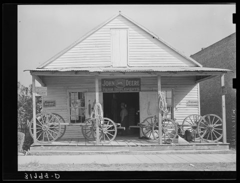 Wagons on porch of farm implements dealer. Erath, Louisiana