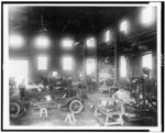 Men working on automobiles in vocational training station