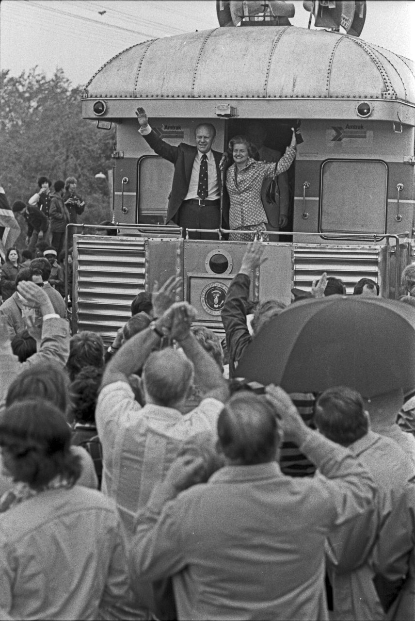 President and Mrs. Ford wave during their primary campaign in Michigan