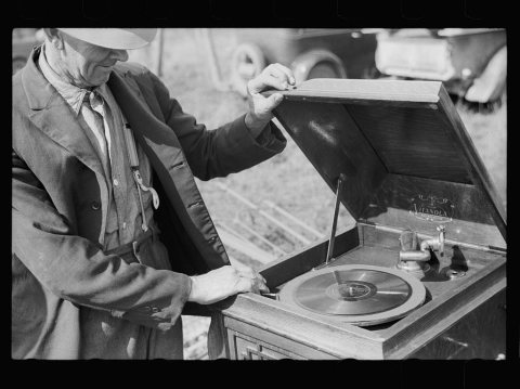 Farmer examining phonograph. Auction near Tenstrike, Minnesota