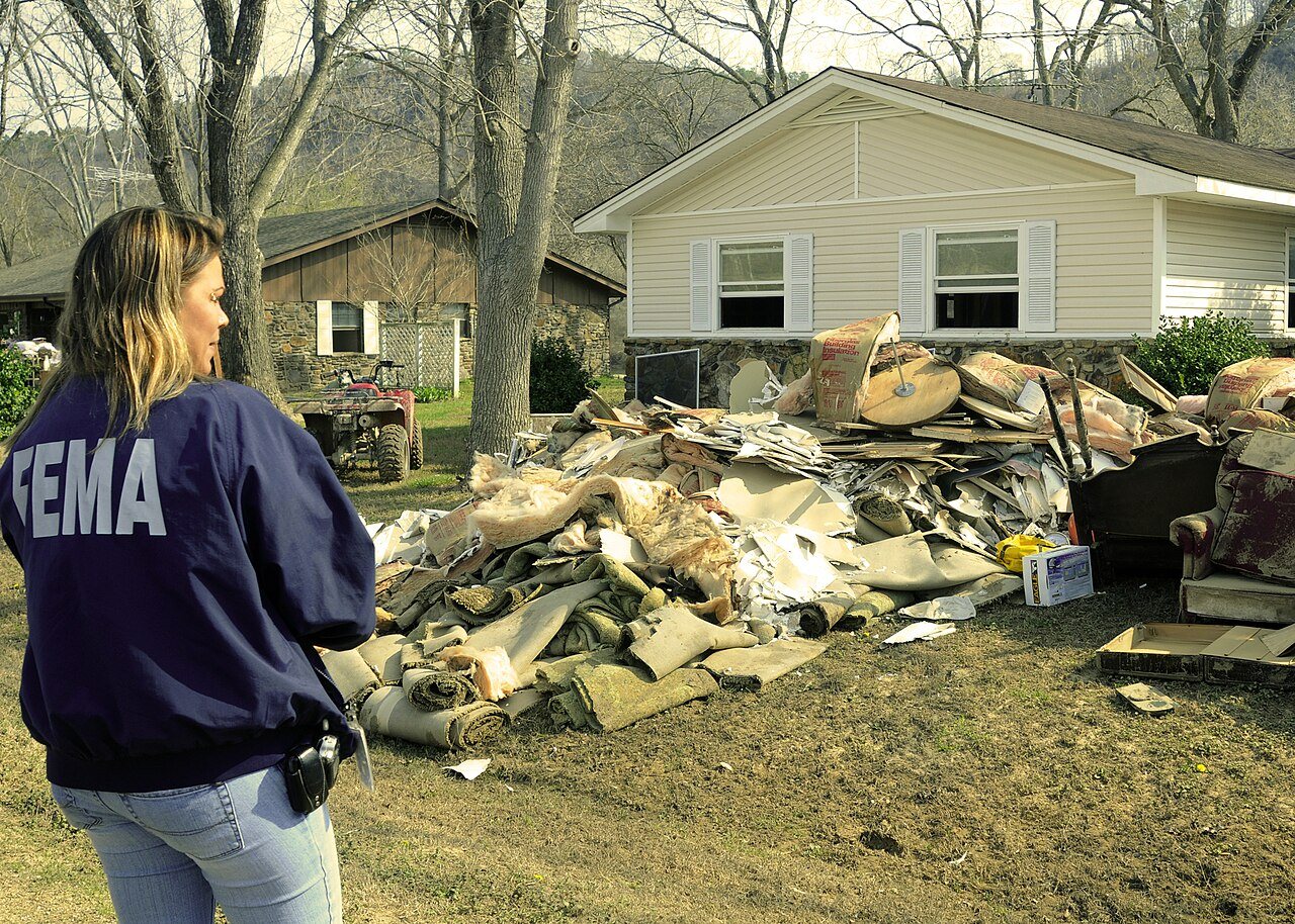 FEMA - 34650 - FEMA worker looks at debris in front of a home in Arkansas